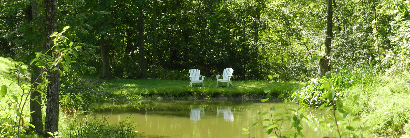 Calming pond of Water with two white chairs